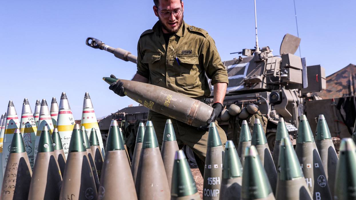 An IDF soldier readies a 155mm artillery shell for loading in a howitzer.