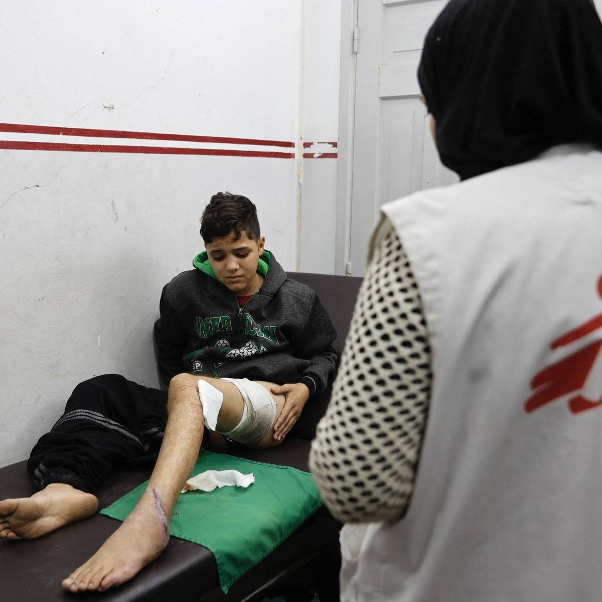 An injured Palestinian boy receives treatment from a member of Doctors Without Borders