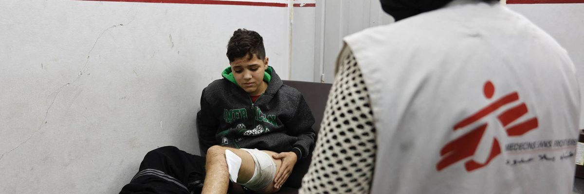 An injured Palestinian boy receives treatment from a member of Doctors Without Borders