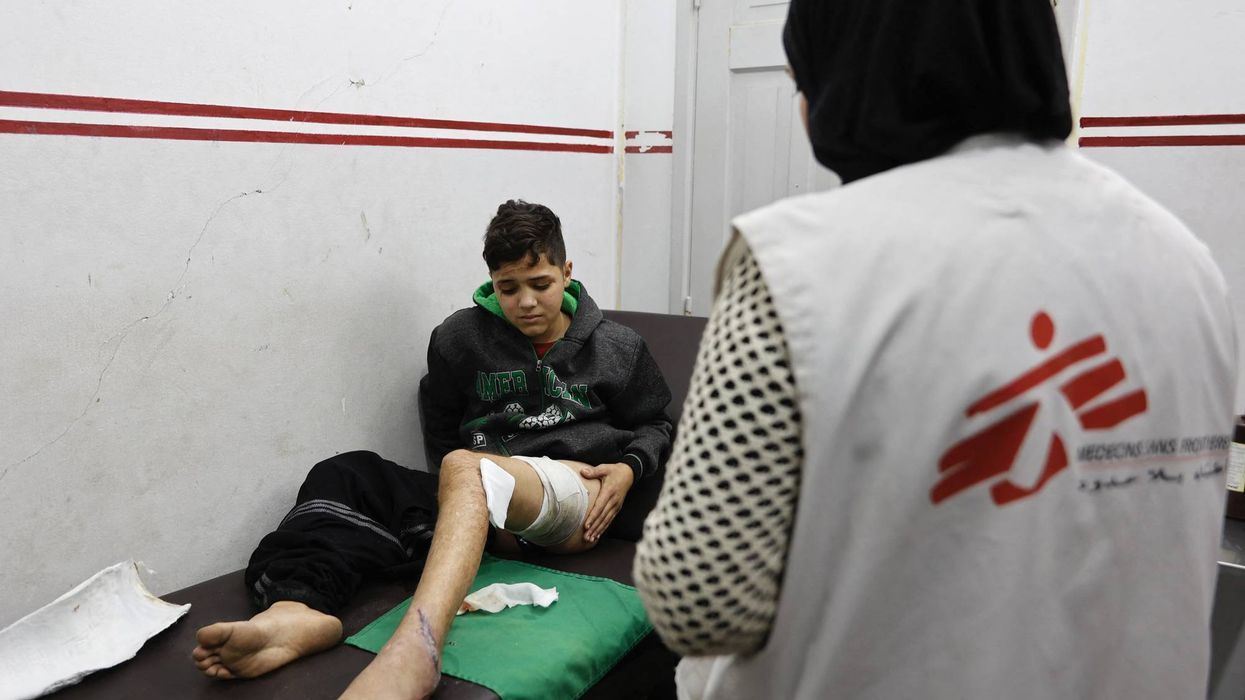 An injured Palestinian boy receives treatment from a member of Doctors Without Borders