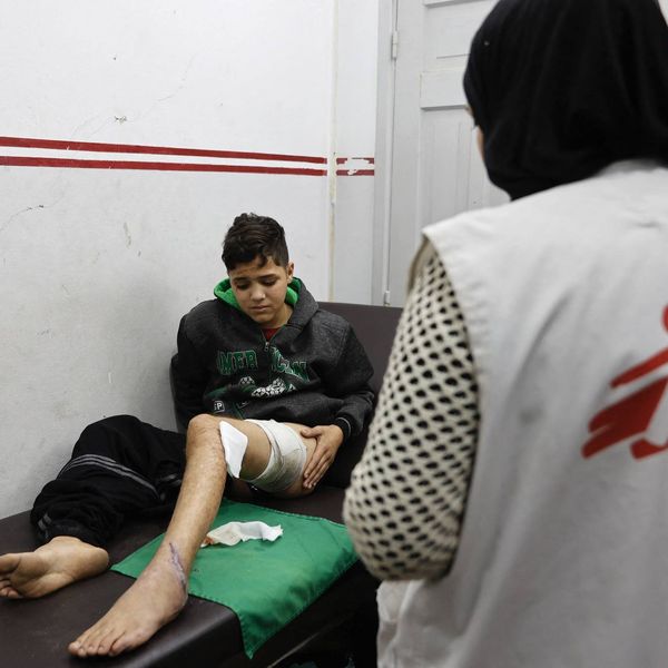 An injured Palestinian boy receives treatment from a member of Doctors Without Borders