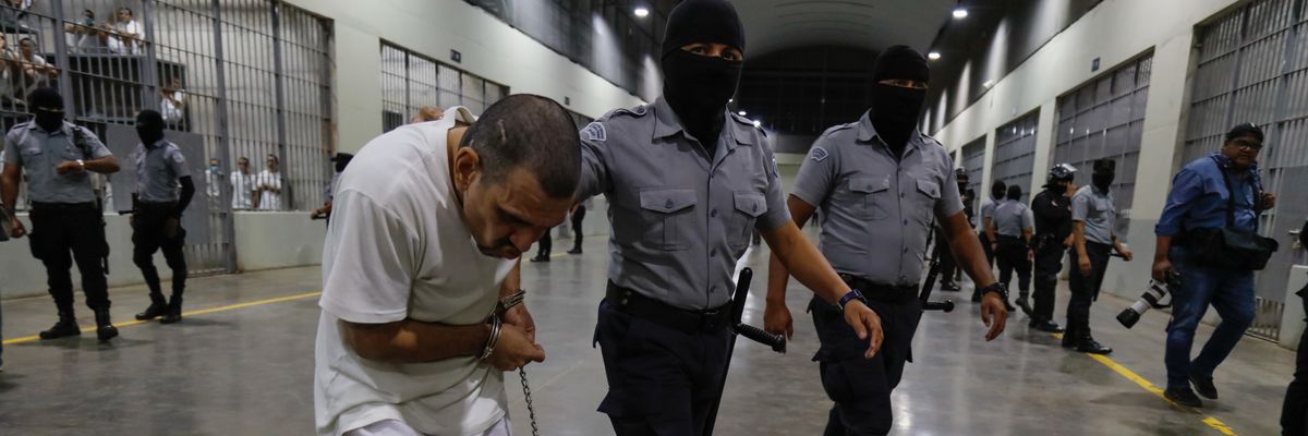 An inmate is escorted by a guard