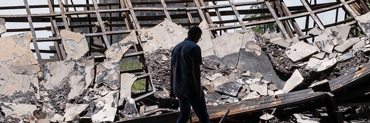 An Iranian man walks through the debris of the headquarters of the Islamic Republic of Iran News Network
