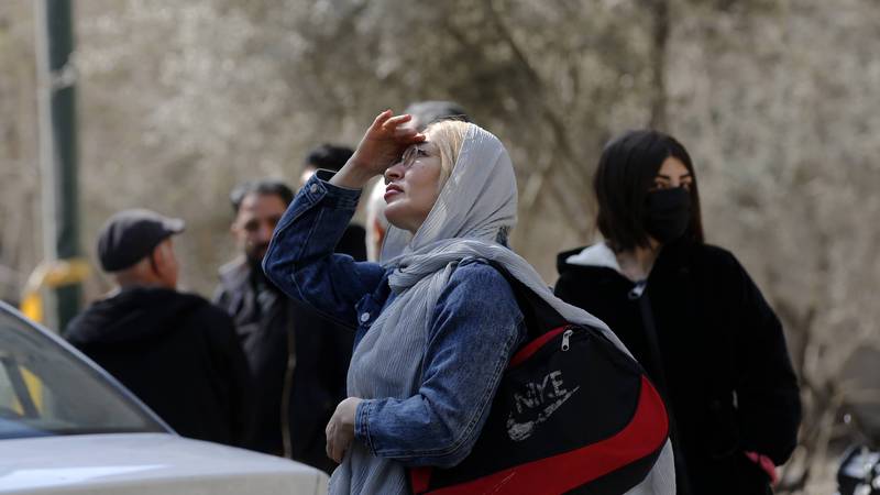 An Iranian woman looks to the sky amid US-Israeli airstrikes