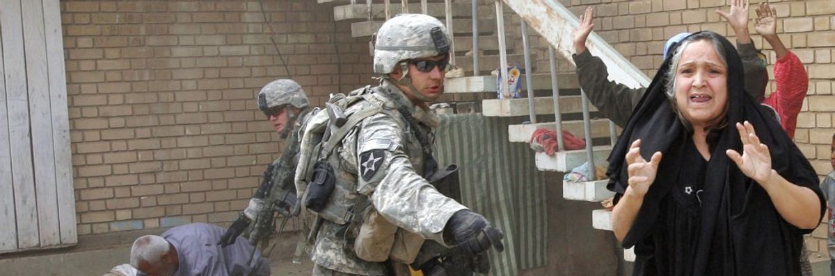 An Iraqi woman shouts "Don't shoot!" as US soldiers detain her family