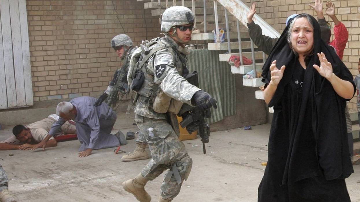 An Iraqi woman shouts "Don't shoot!" as US soldiers detain her family