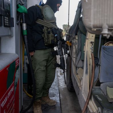 An Israel Defense Forces soldier fills a hummer with gas