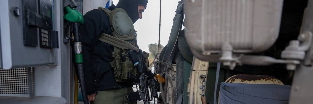 An Israel Defense Forces soldier fills a hummer with gas