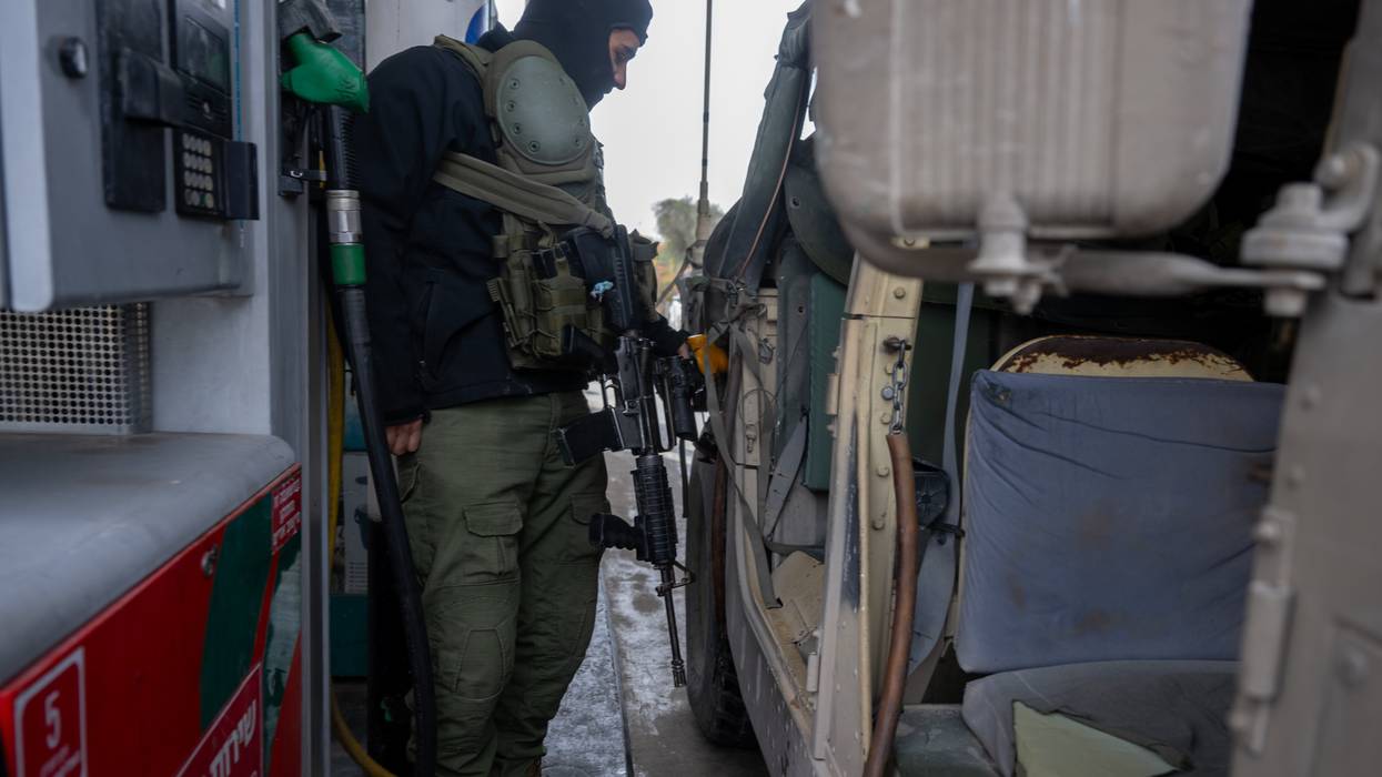 An Israel Defense Forces soldier fills a hummer with gas