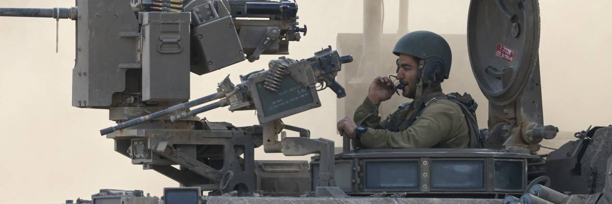 an Israeli army soldier sitting on an armored personnel carrier