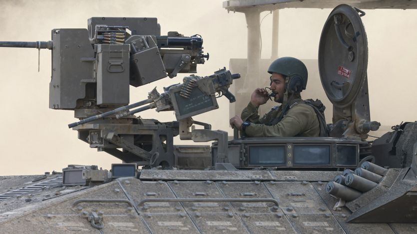an Israeli army soldier sitting on an armored personnel carrier