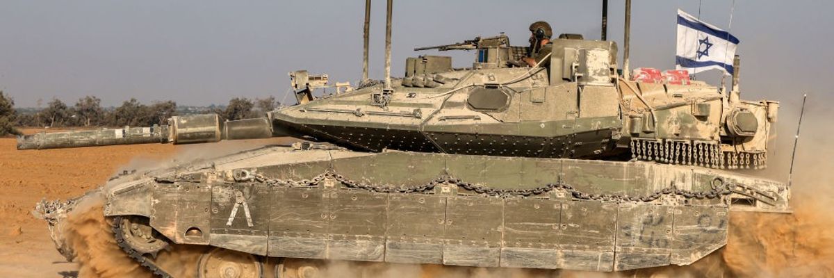 An Israeli flag flies in the back of a main battle tank