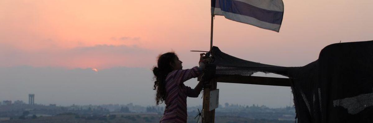 An Israeli girl raises an Israeli flag