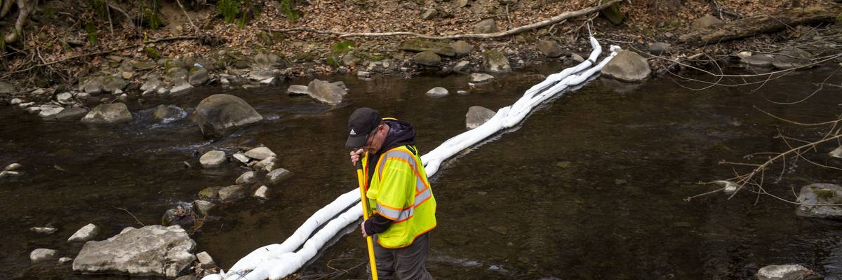 An Ohio EPA emergency response worker looks for signs of fish and agitates the water in East Palestine