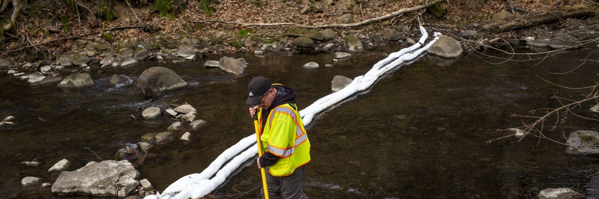 An Ohio EPA emergency response worker looks for signs of fish and agitates the water in East Palestine