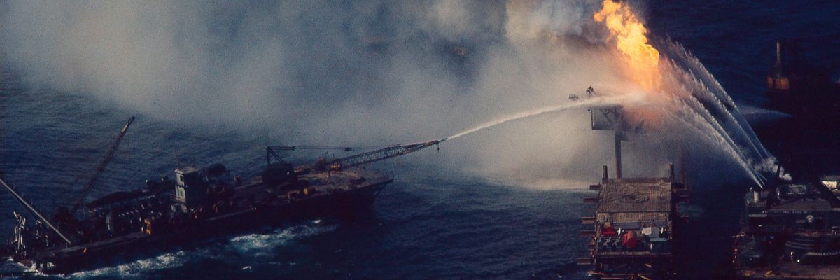 An oil drilling rig on fire in the Gulf of Mexico