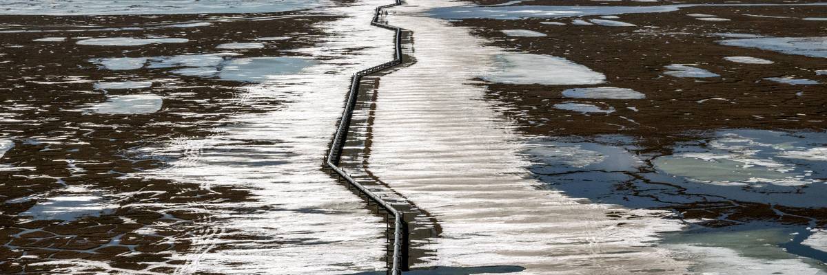 An oil pipeline stretches across the landscape outside Prudhoe Bay in North Slope Borough, Alaska