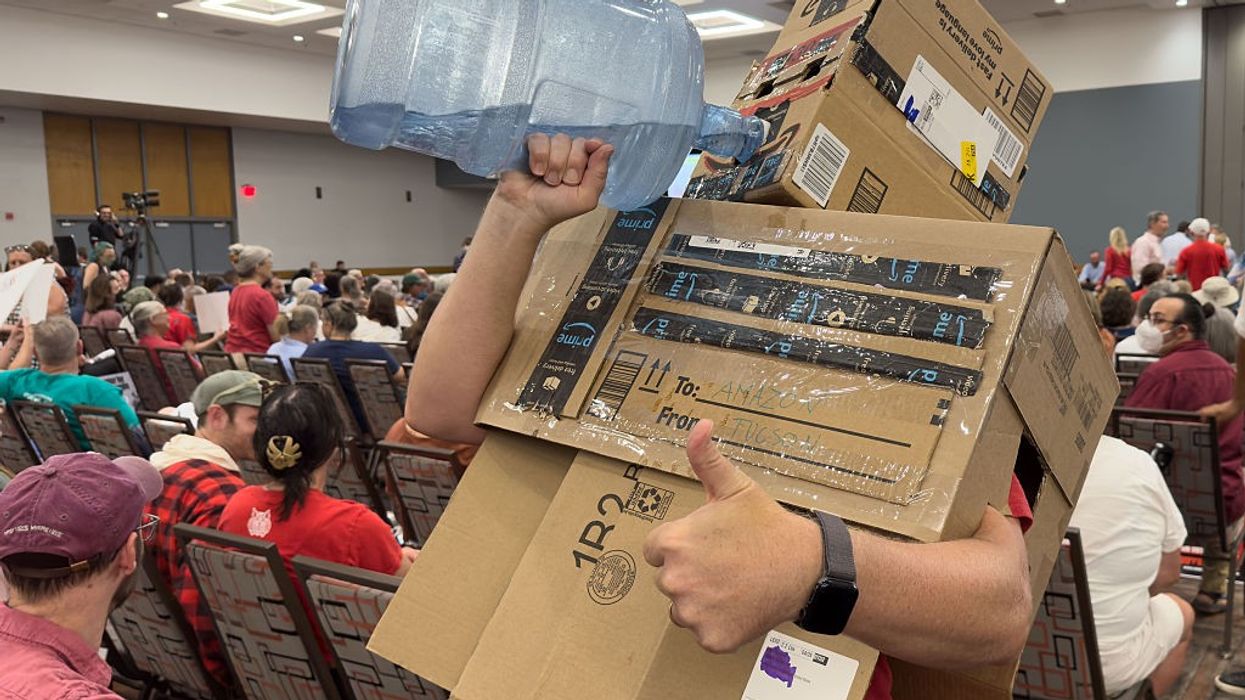 An protester guzzles water while dressed as a data center.