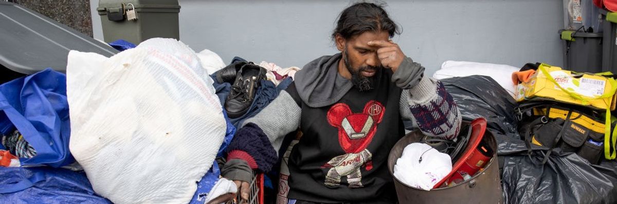 An unhoused man is distraught as he is forced to dismantle his home and possessions in New York City