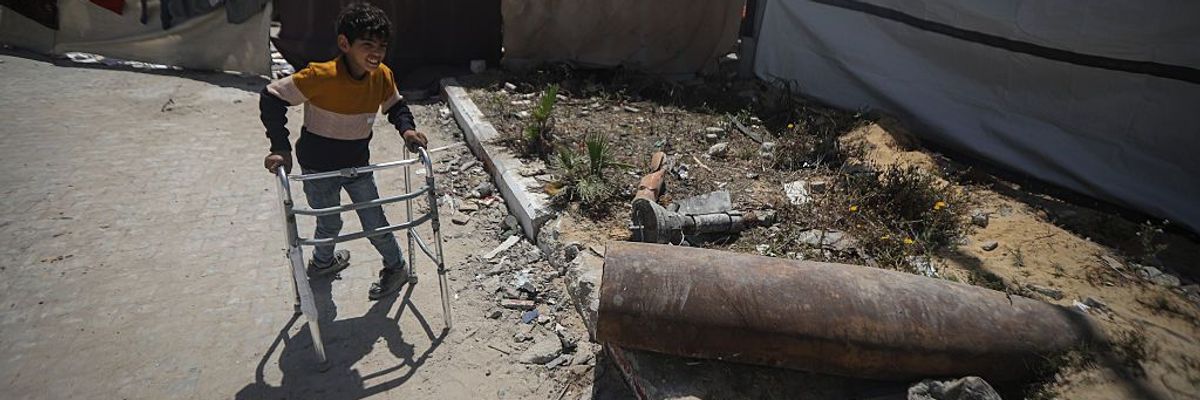 An unjured Palestinian boy approaches an unexploded IDF bomb in Gaza