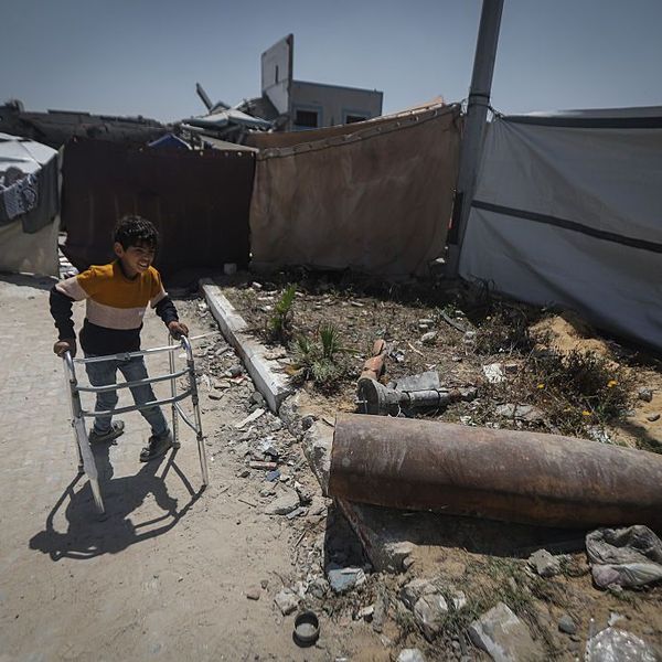 An unjured Palestinian boy approaches an unexploded IDF bomb in Gaza