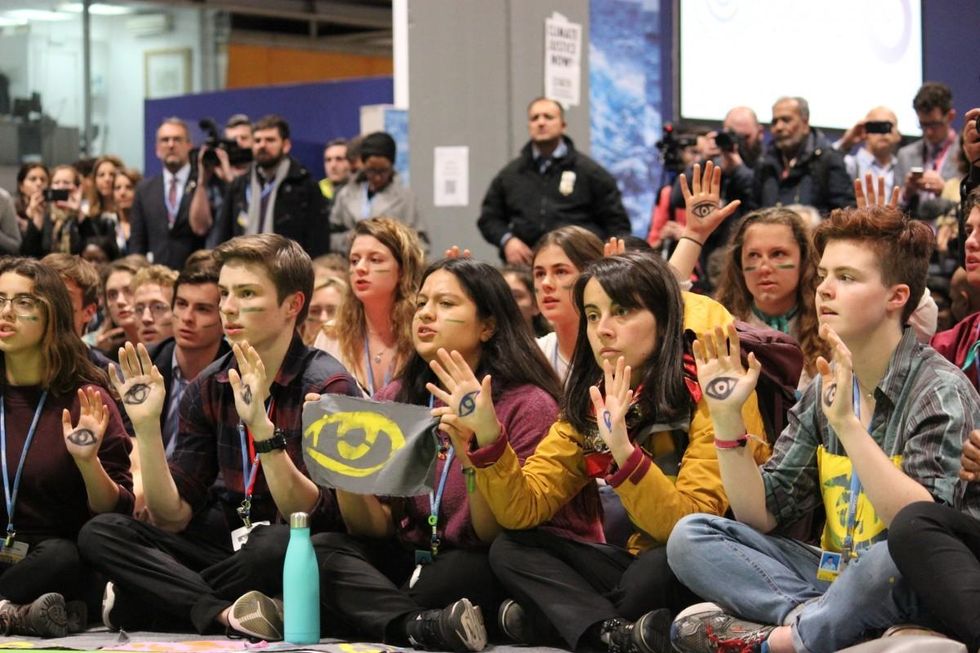 Angela Valenzuela (second from right) at a Fridays for Future sit-in during the final day of the UNFCCC COP25 in Madrid, Spain. Activists painted eyes on their hands to bring attention to the state violence toward civil society groups during the uprisings in Chile. (Photo: Katherine Quaid/WECAN International)