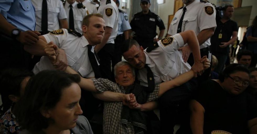 Another climate protester being forcibly removed by security at the Parliament House.  (Photo: 350 .org/flickr/cc)