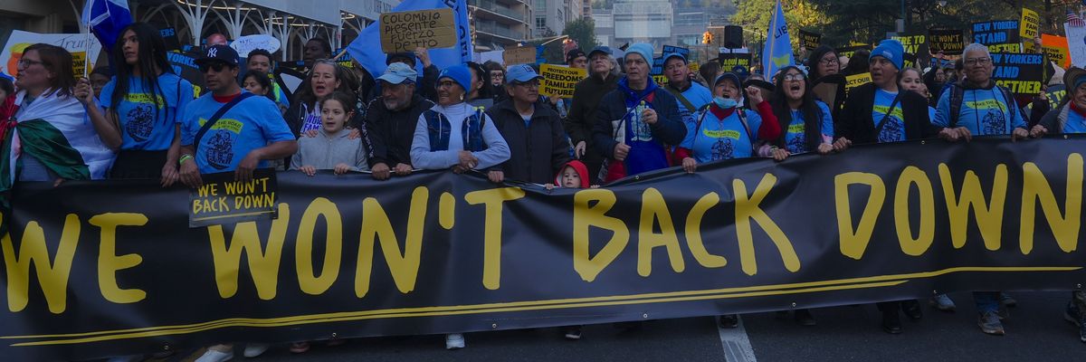 Anti-Trump protesters carry sign reading, "We won't back down."