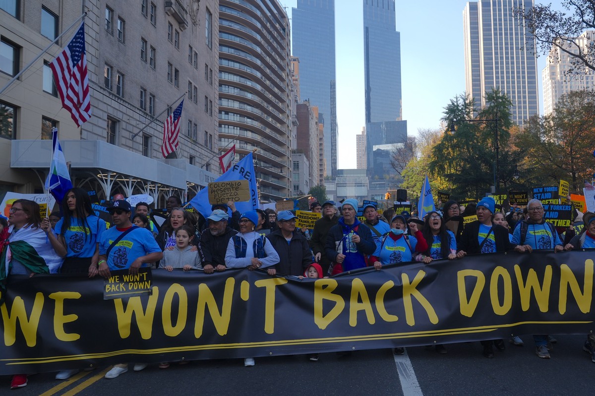 Anti-Trump protesters carry sign reading, "We won't back down."