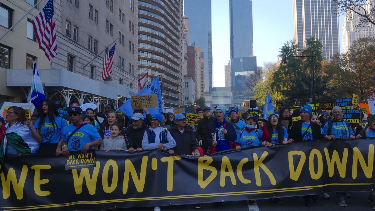 Anti-Trump protesters carry sign reading, "We won't back down."