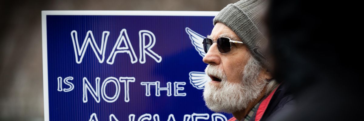 Anti-war protester holds up sign reading "War Is Not the Answer"