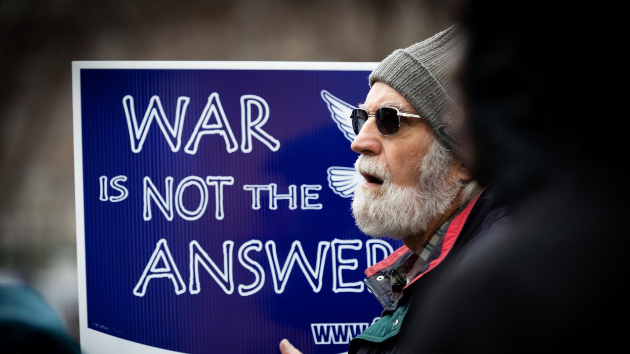 Anti-war protester holds up sign reading "War Is Not the Answer"
