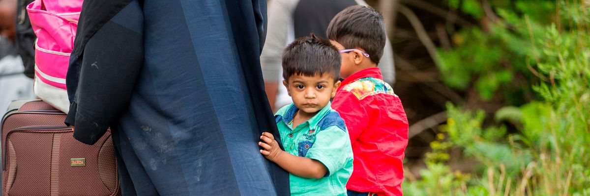 Asylum seekers wait to cross into Canada from the US