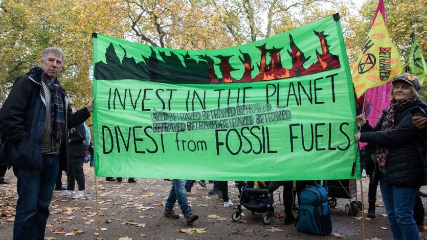 Banner says, "Invest in the planet, divest from fossil fuels."