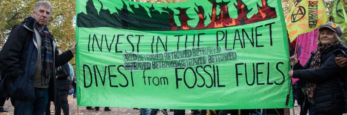 Banner says, "Invest in the planet, divest from fossil fuels."