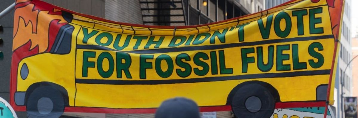 Banner, with school bus design, reads Youth Didn't Vote For Fossil Fuels, March to End Fossil Fuels
