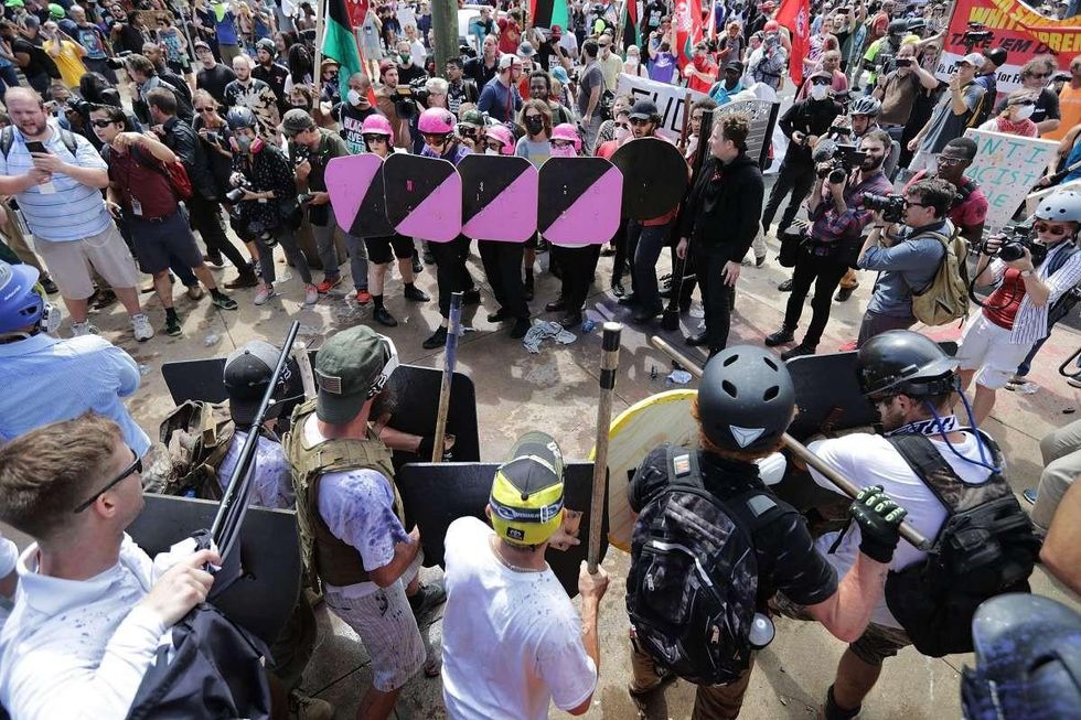 Battle lines form between white nationalists, neo-Nazis and members of the 'alt-right' and anti-fascist counter-protesters at the entrance to Lee Park during the 'Unite the Right' rally August 12, 2017 in Charlottesville, Virginia. After clashes with anti-fascist protesters and police the rally was declared an unlawful gathering and people were forced out of Lee Park, where a statue of Confederate General Robert E. Lee is slated to be removed. (Photo by Chip Somodevilla/Getty Images)