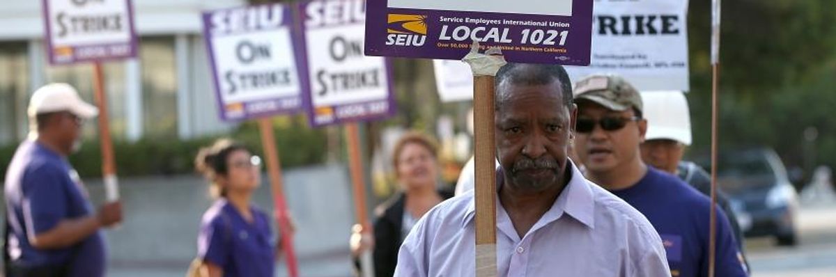 Bay Area Rapid Transit (BART) union workers with SEIU Local 1021 hold signs as they picket in front of the Lake Merritt station on July 2, 2013 in Oakland, California