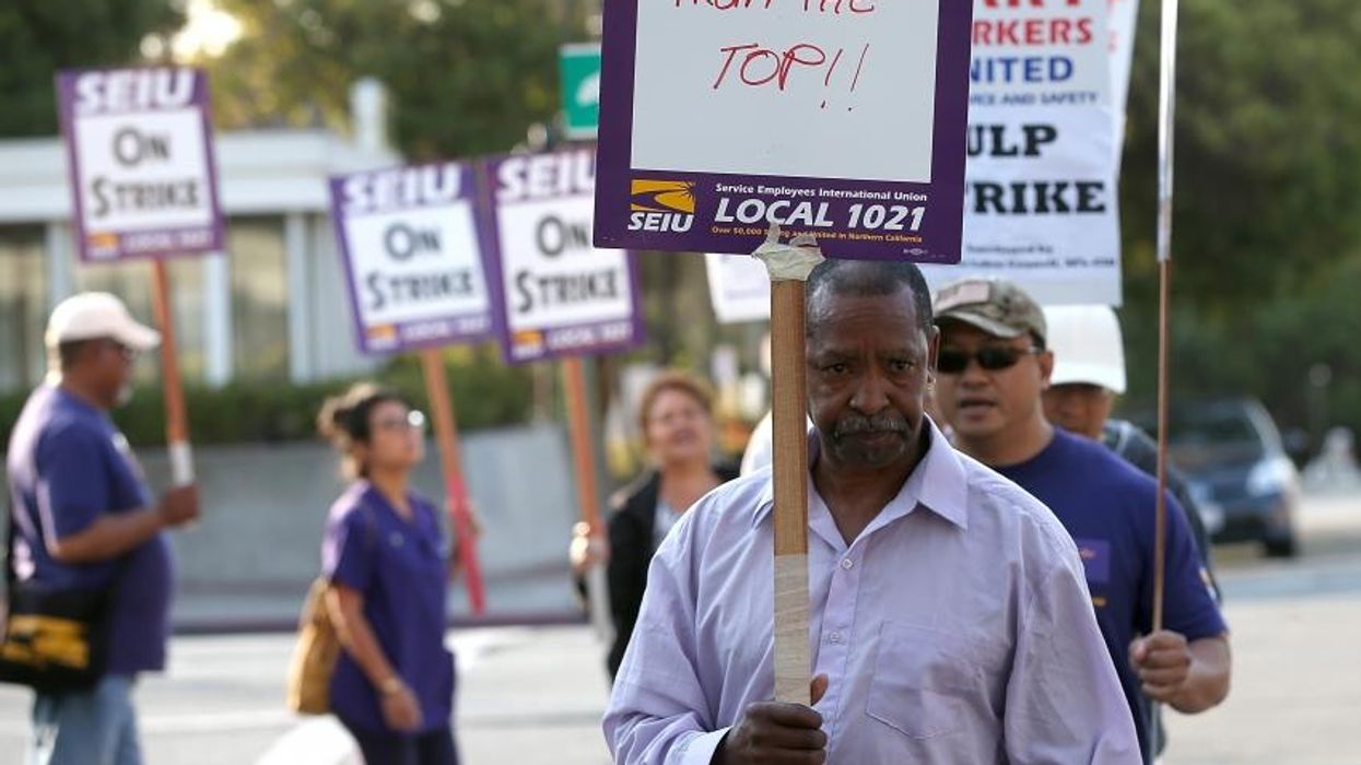 Bay Area Rapid Transit (BART) union workers with SEIU Local 1021 hold signs as they picket in front of the Lake Merritt station on July 2, 2013 in Oakland, California