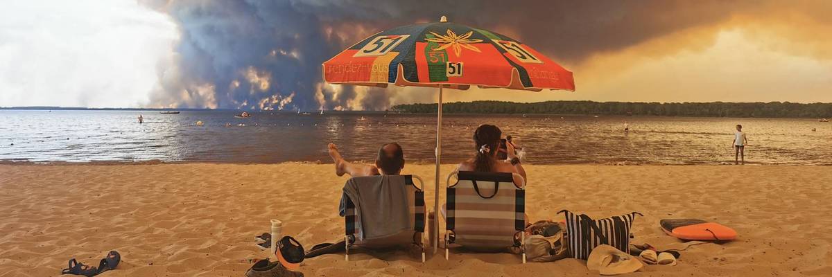 Beach goers watch a wildfire in France