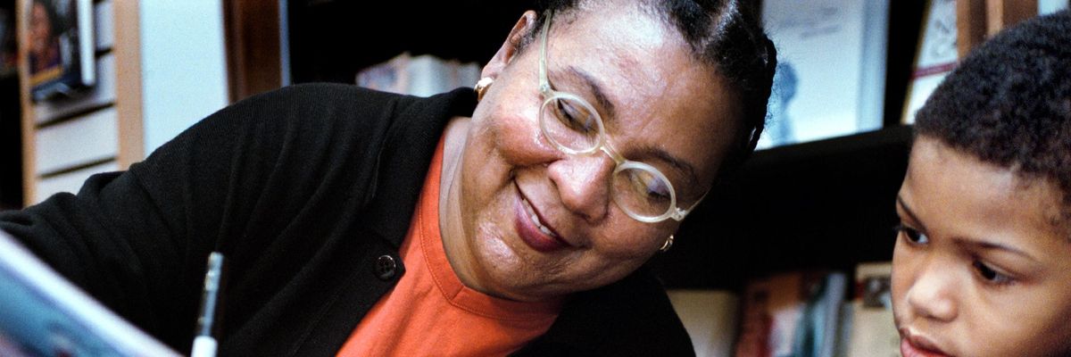 bell hooks signs a book for a young reader.