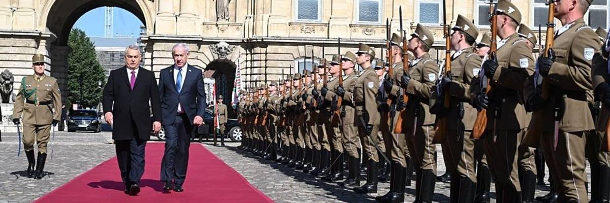 Benjamin Netanyahu and Viktor Orbán walk along a red carpet while Hungarian soldiers stand at attention