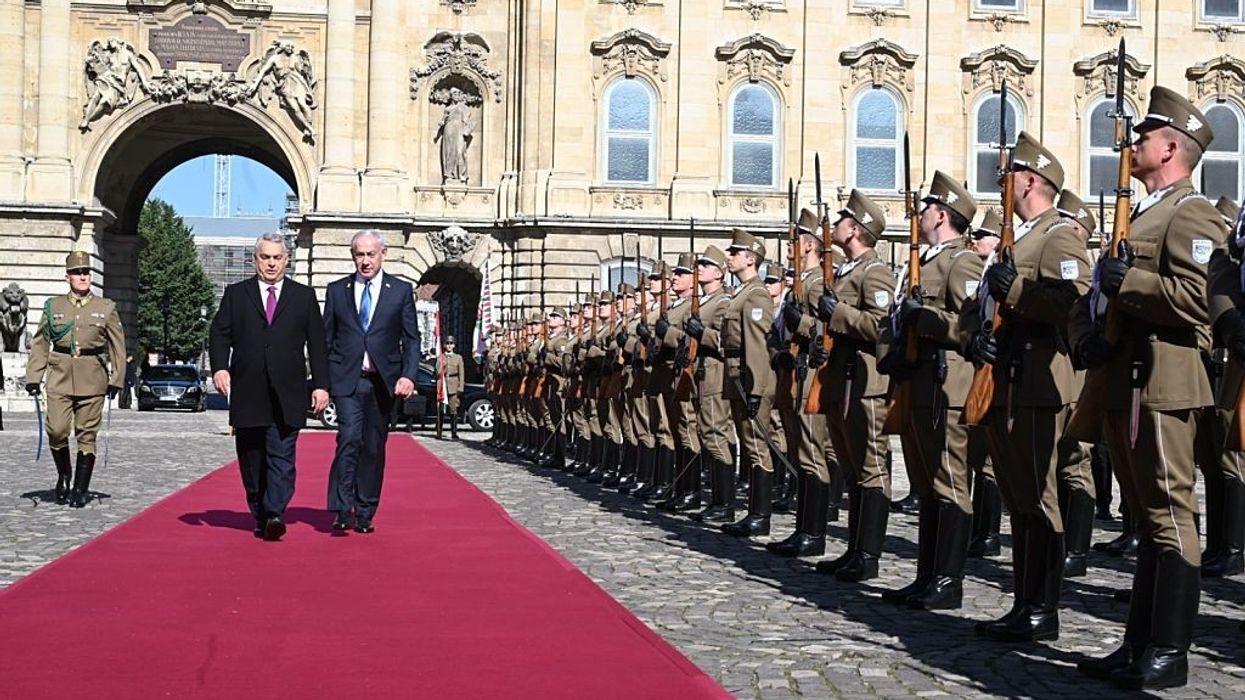 Benjamin Netanyahu and Viktor Orbán walk along a red carpet while Hungarian soldiers stand at attention