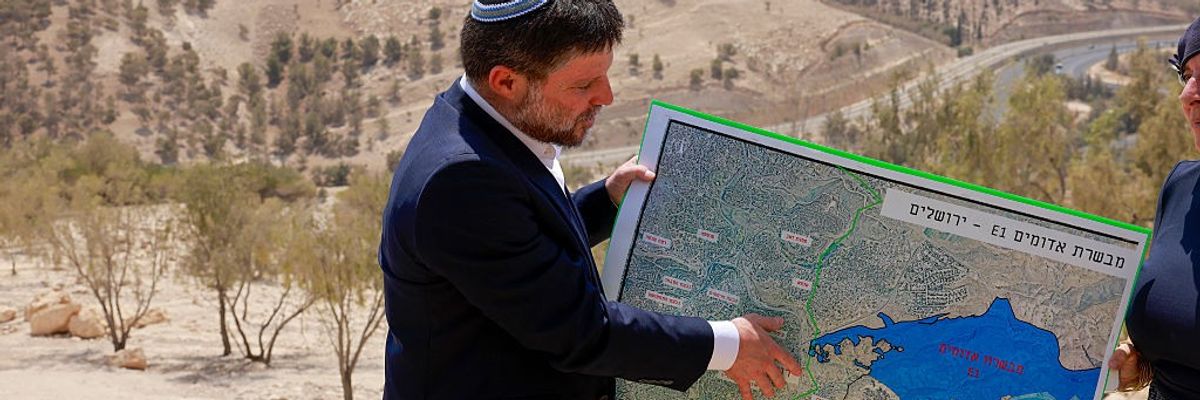 Bezalel Smotrich holds a map of an area in the illegally occupied West Bank of Palestine
