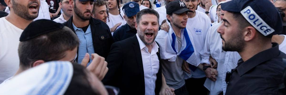 Bezalel Smotrich, wearing a suit without a tie, smiles during the Jerusalem Flag Day march