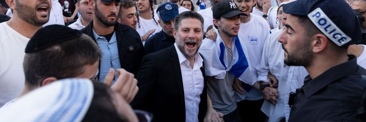 Bezalel Smotrich, wearing a suit without a tie, smiles during the Jerusalem Flag Day march