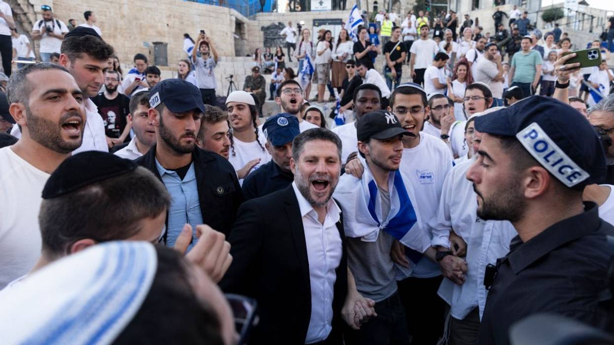 Bezalel Smotrich, wearing a suit without a tie, smiles during the Jerusalem Flag Day march