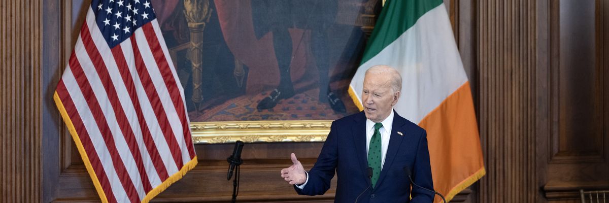 Biden between the U.S. and Irish flags.