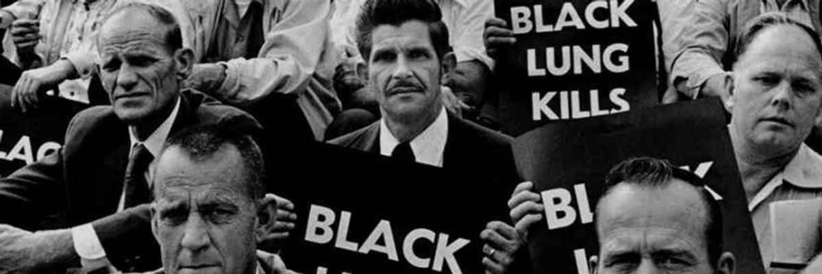 Black and white image of miners holding signs reading, "Black lung kills."