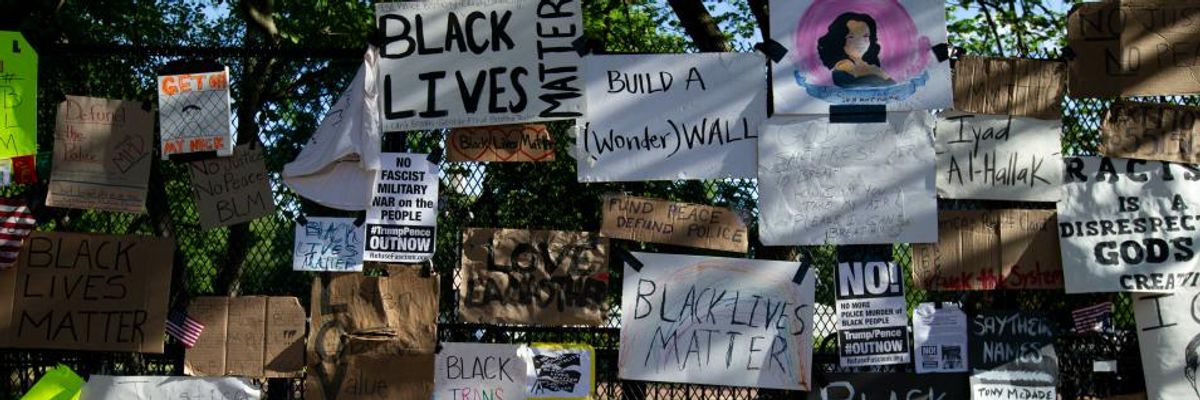 Black Lives Matter protest signs on White House fence.